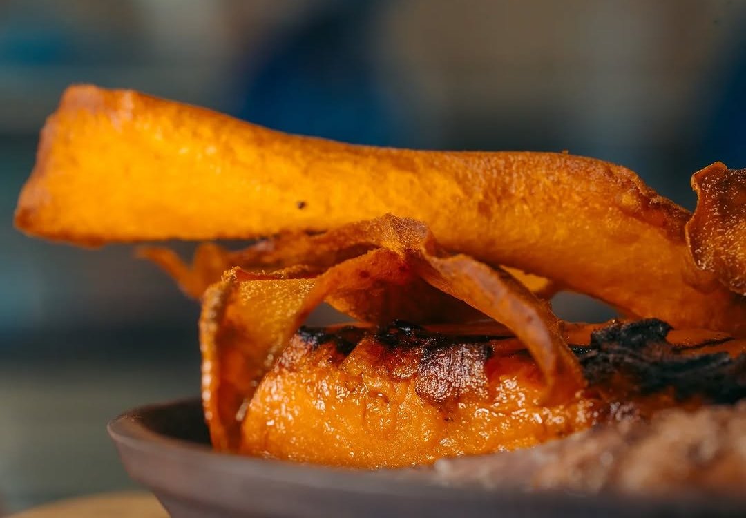 Batata-doce assada e em lascas fritas, numa taça de barro
